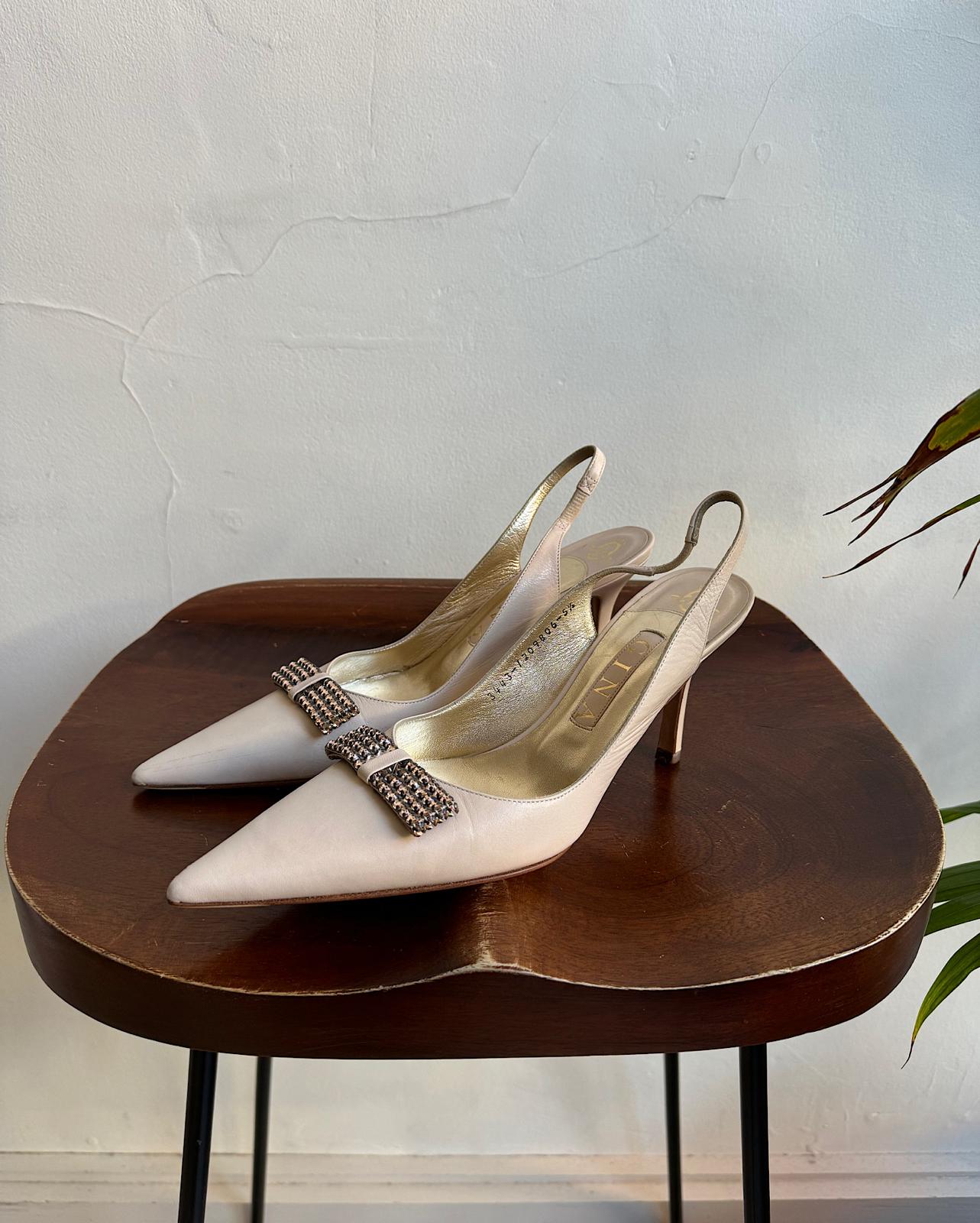 Side view of beautiful pair of new cream slingbacks by Gina, featuring pale pink diamanté bows.