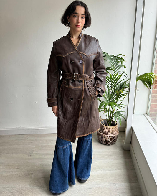 Front view of striking brown distressed leather coat by Acne Studios worn belted.