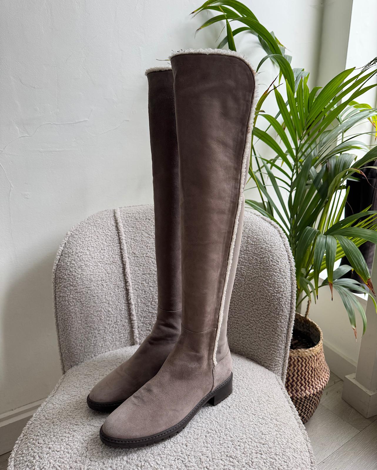 Front view of fashionable pair of suede parka over-the-knee boots from Stuart Weitzman, featuring a shearling trim