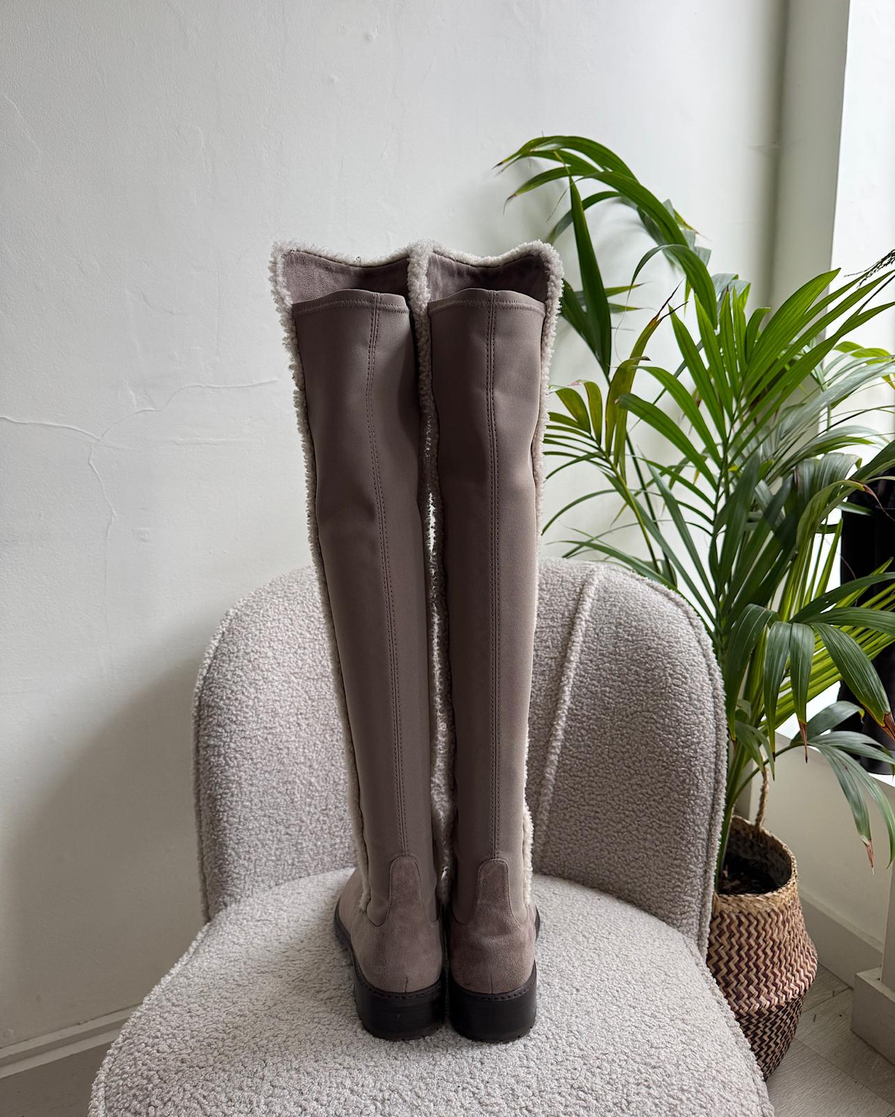 Back view of fashionable pair of suede parka over-the-knee boots from Stuart Weitzman, featuring a shearling trim