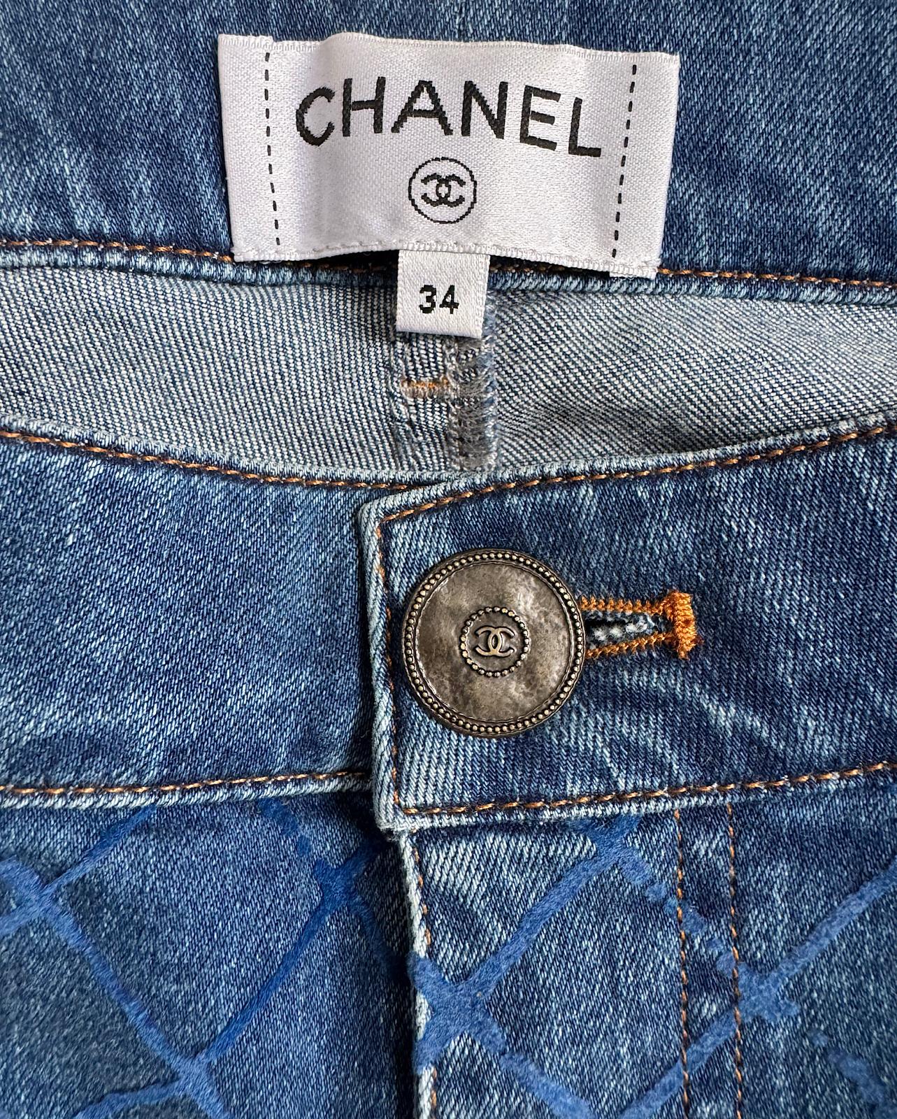 label and button detail of stunning pair of blue slim-fit denim jeans by Chanel, featuring an all-over textured pattern and ankle zippers