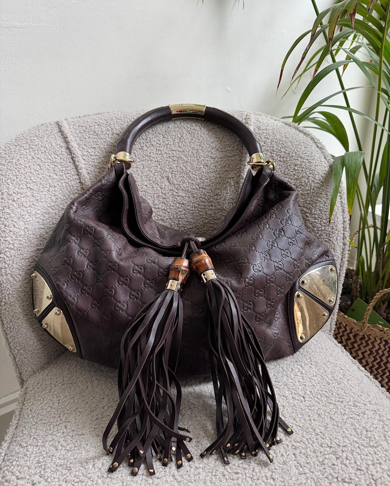 Front view of beautiful dark brown medium Indy bag by Gucci, embellished with tassels