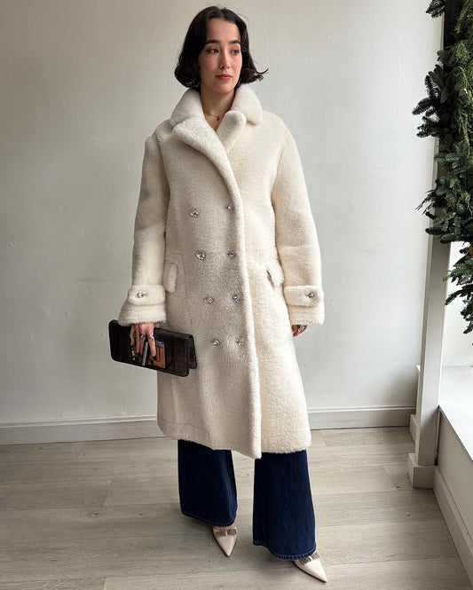 Front view of luxurious shearling coat by Tom Ford. Crafted from plush, high-quality shearling, this double-breasted coat combines sophistication and warmth.