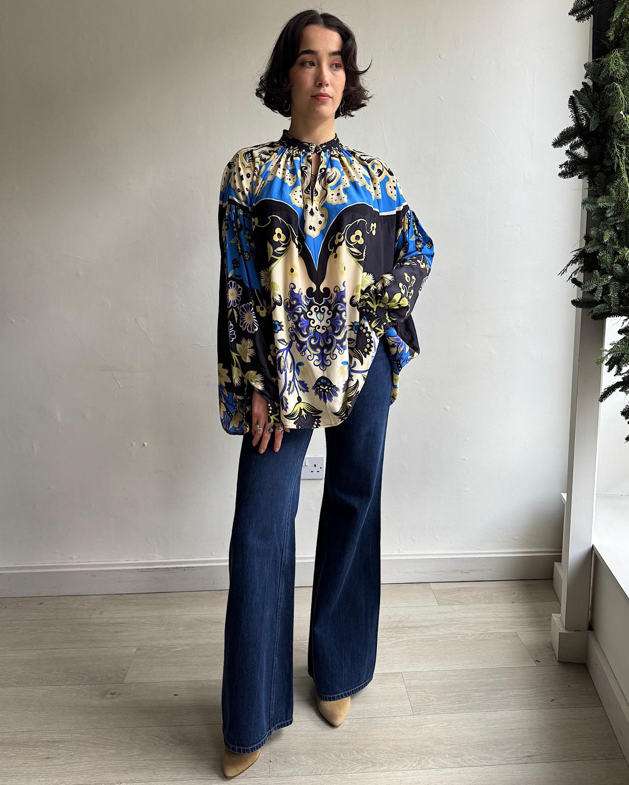 Front view of colorful silk blouse by Etro featuring a single button at the neck opening, balloon sleeves, and a mandarin collar