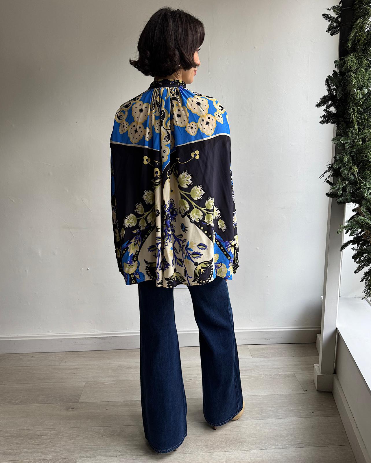 Back view of colorful silk blouse by Etro featuring a single button at the neck opening, balloon sleeves, and a mandarin collar