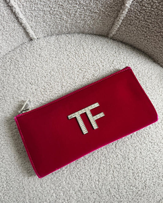 Front view of stunning red velvet clutch by Tom Ford showcases a beaded crystal 'TF' logo on the front and features a zip-top closure.