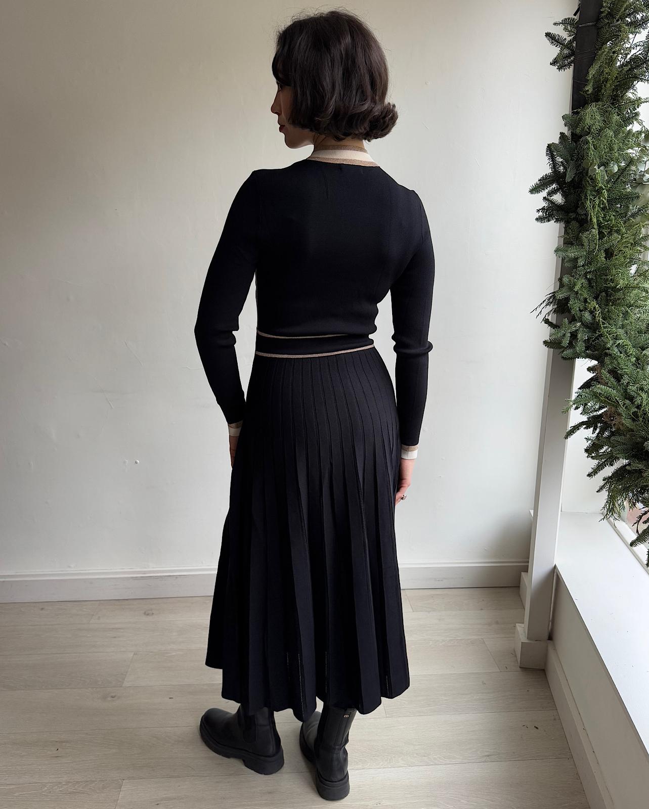 Back view of elegant black long sleeve dress by ME+EM features a pleated skirt and a half zipper up the front.