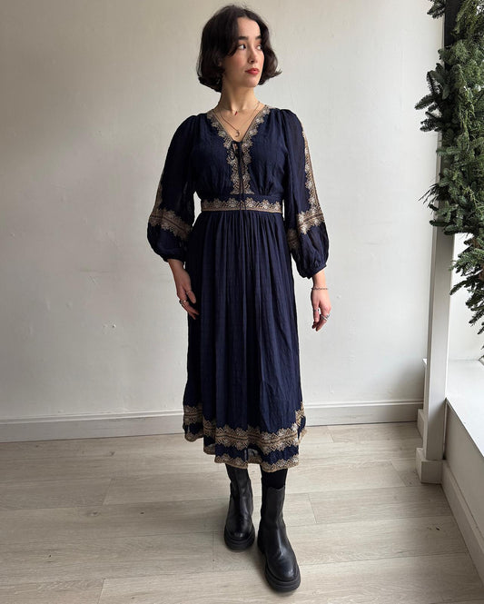 Front view of beautiful navy embroidered Teroli dress by Vanessa Bruno featuring a deep neckline with ties, long puffed sleeves cinched at the wrists 