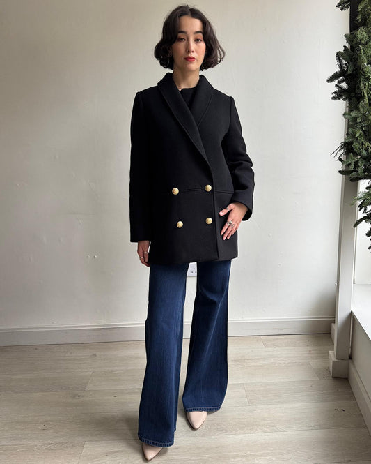 Front view of black James coat by Sezane features a double-breasted front, a shawl collar, and two inlaid pockets