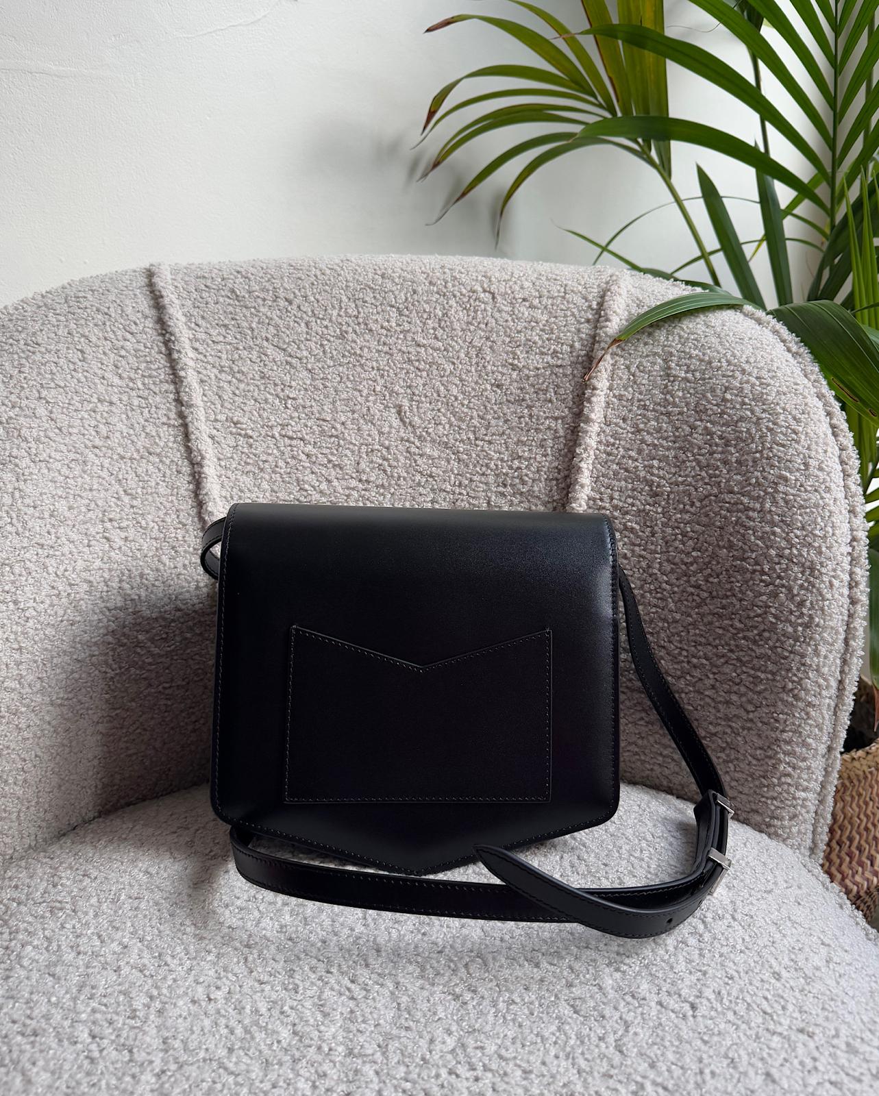 Back view of expertly crafted Le Papa crossbody bag by Alaia features a sleek black leather construction complemented by silver-tone hardware.