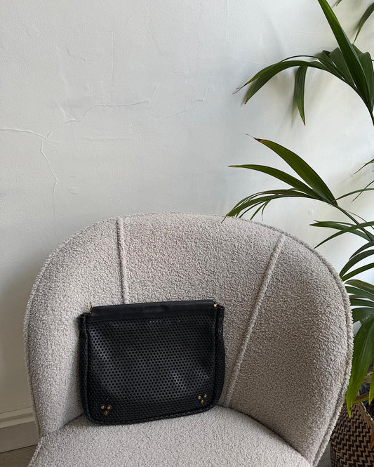 Black 'Popoche' Perforated Clutch sat on armchair